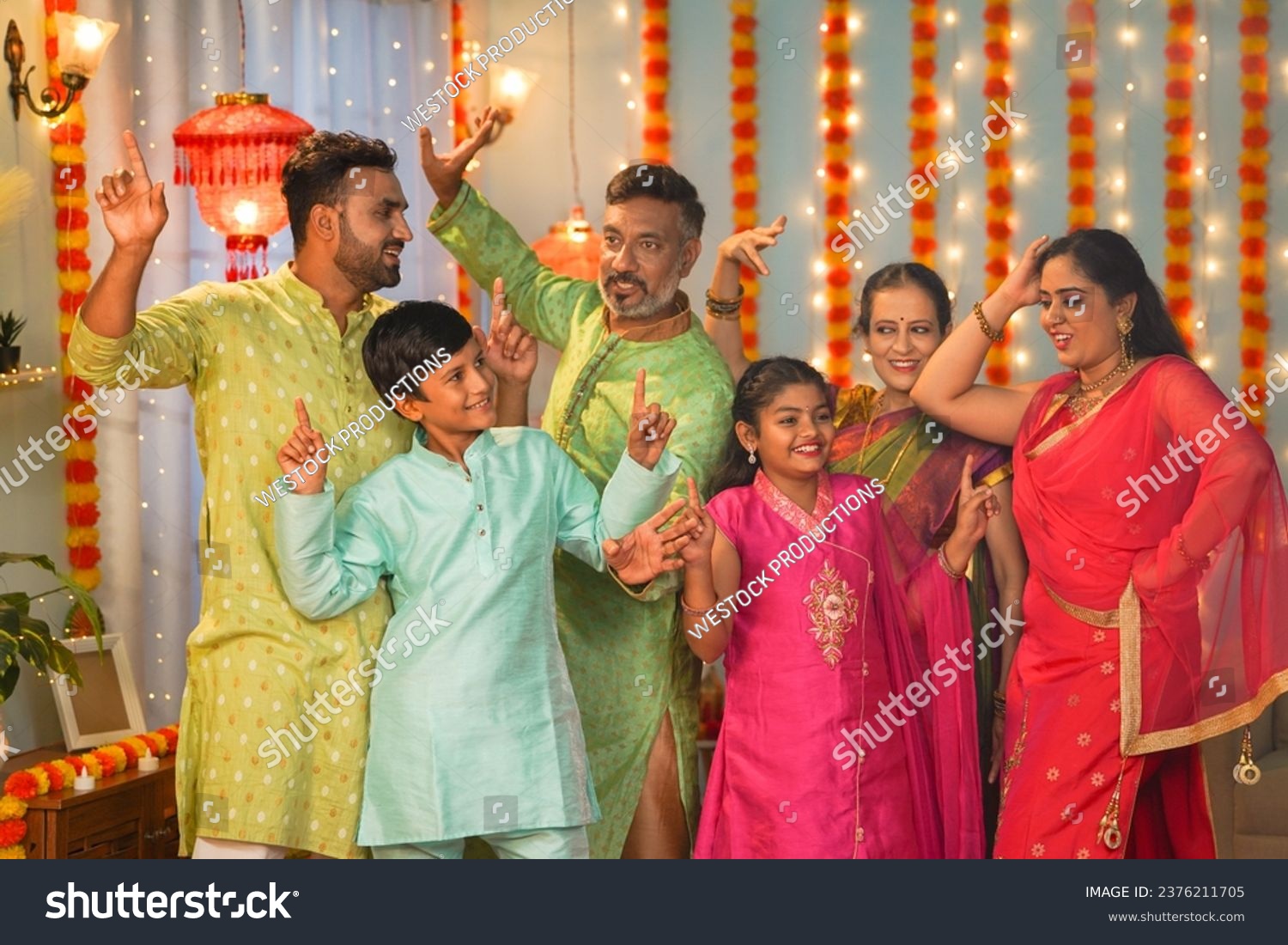 Group of family members dancing together during diwali festive celebration gathering at home - concept of entertainment, Holiday reunion and enjoyment #2376211705