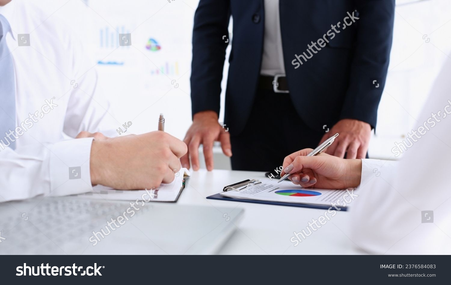 Group of people hold silver pen ready to make note in clipboard pad sheet closeup. Training course university practice homework school or college exercise secretary table management concept #2376584083