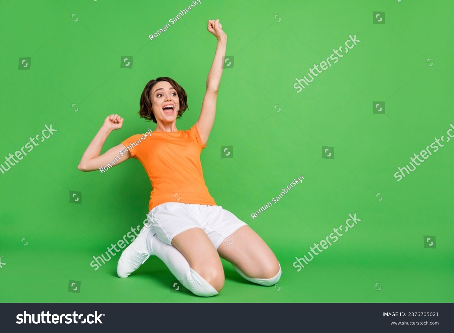 Full body portrait of astonished lady open mouth stand on knees slide look empty space isolated on green color background #2376705021