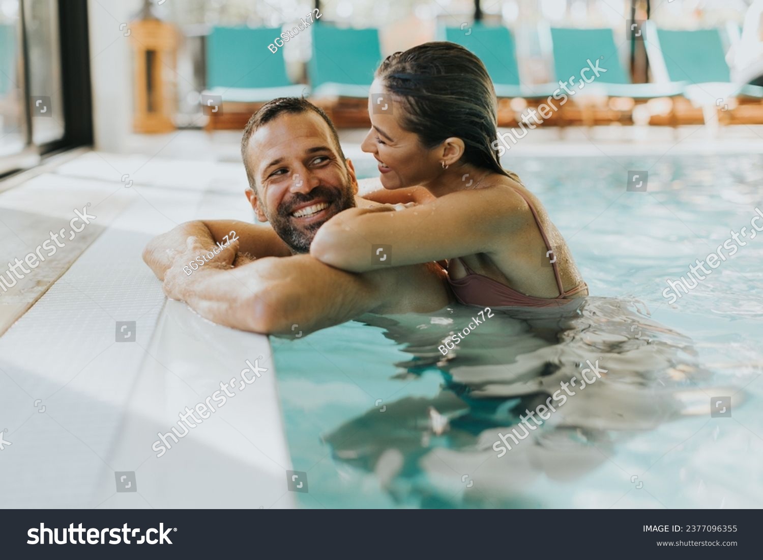 Handsome young couple relaxing in the indoor swimming pool #2377096355