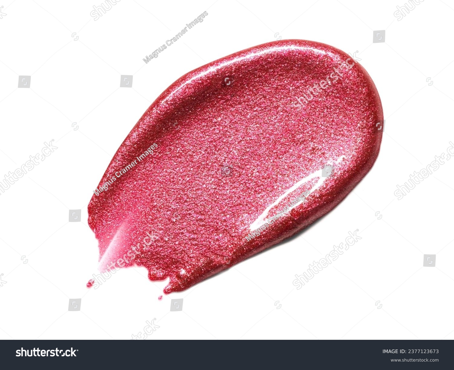 Red metallic shimmering lipgloss texture isolated on white background. Smudged cosmetic product smear. Makup swatch product sample #2377123673