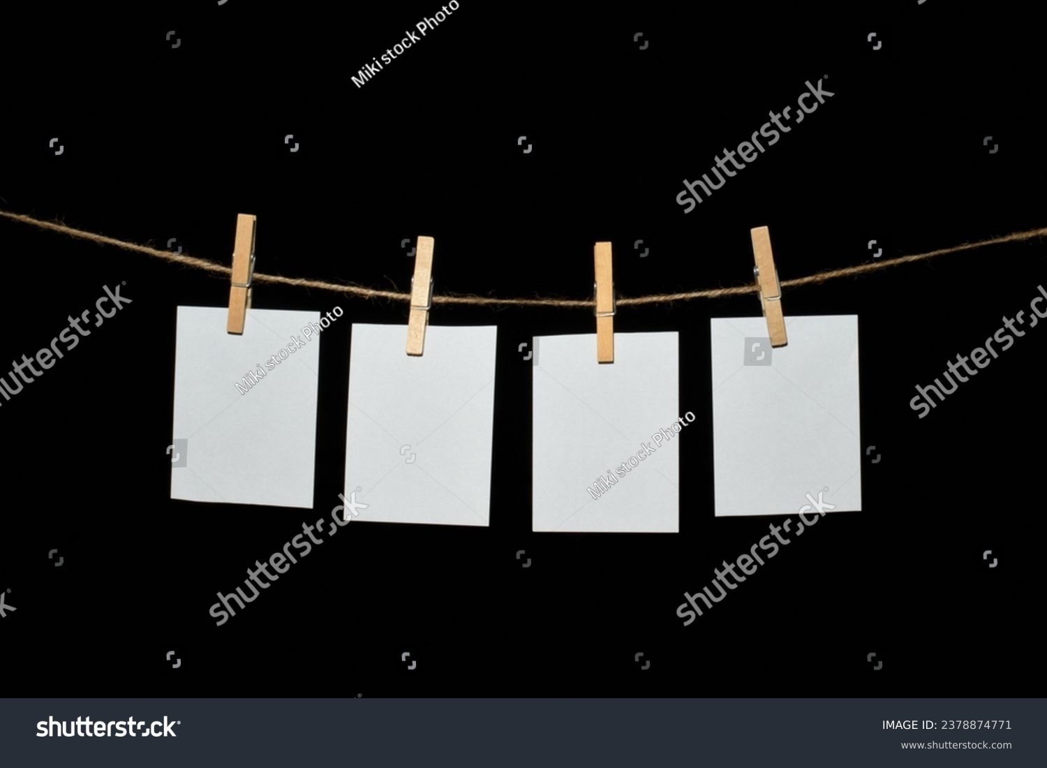 black background with a rope and clothespins holding papers #2378874771