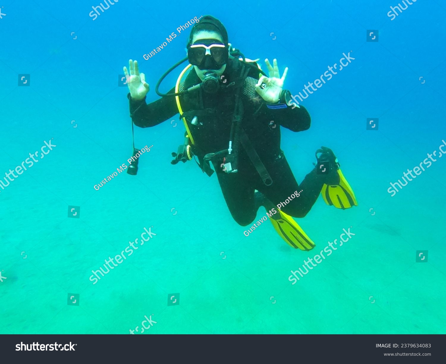 Woman scuba diver alone showing "Ok" signal underwater, "I am Ok", safety check, underwater communication while diving. Water sport concept #2379634083