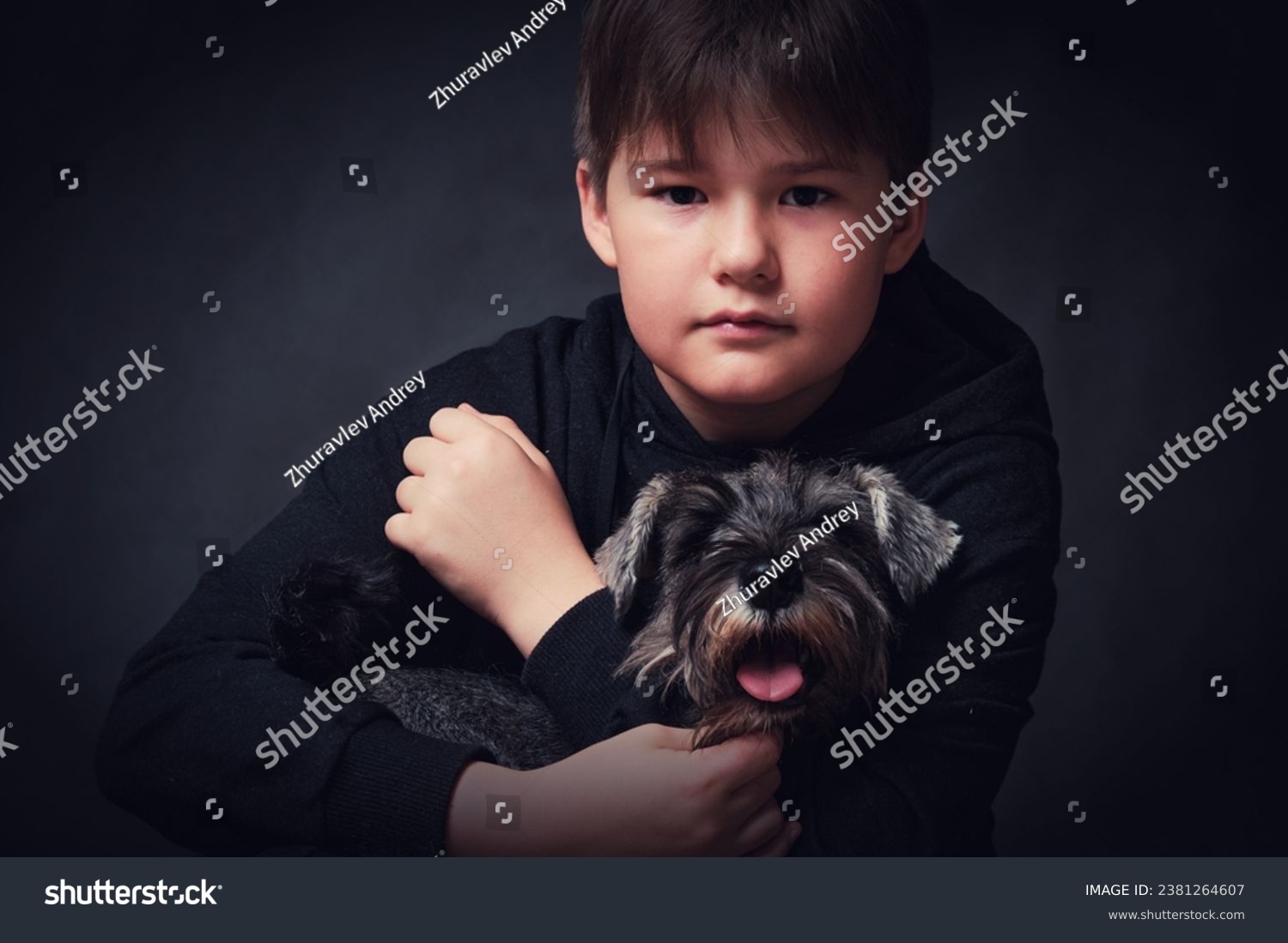Little boy with a dog on a dark background. Studio shot. #2381264607