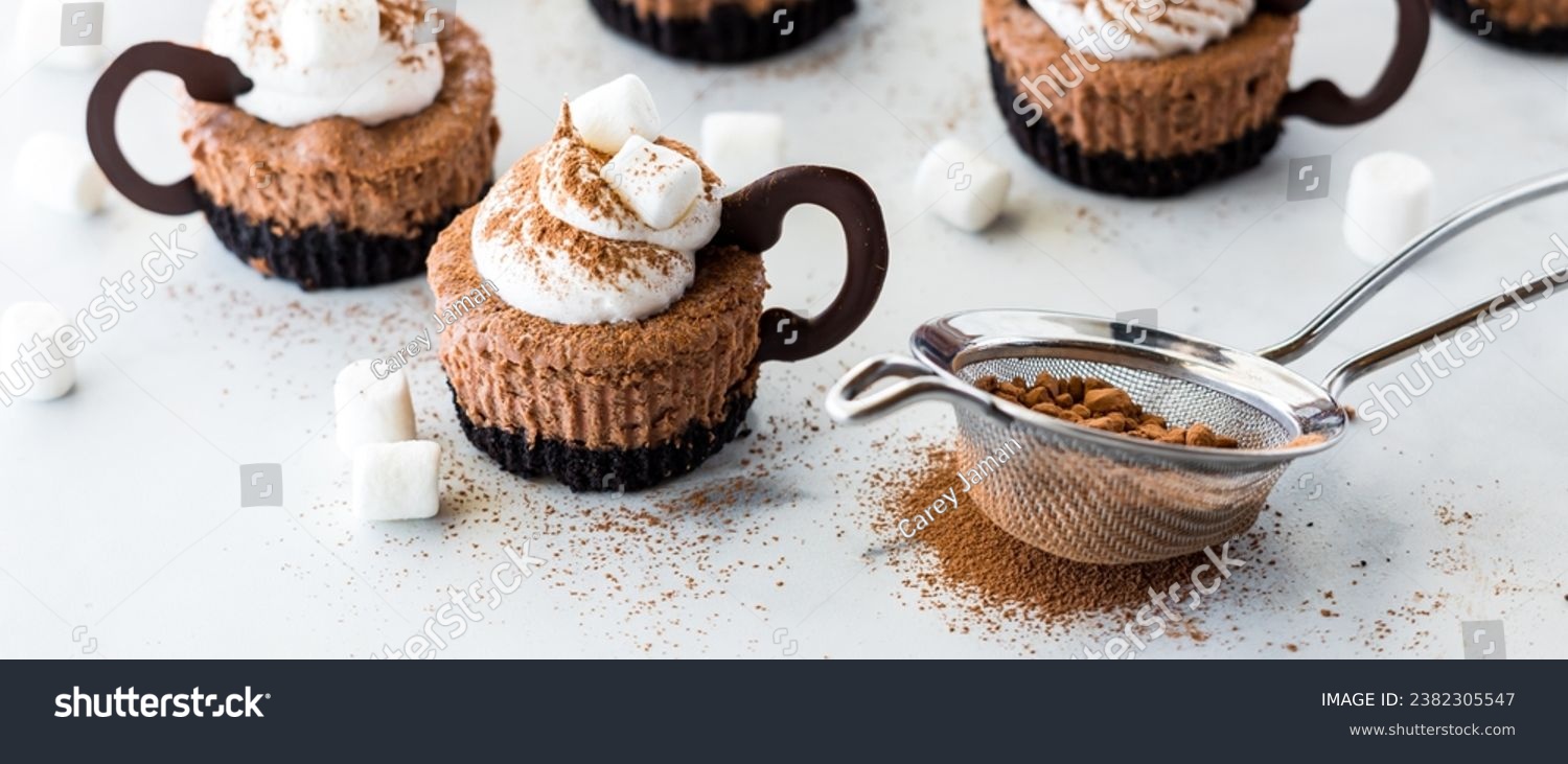 A narrow view of hot cocoa mini cheesecakes dusted with powdered cocoa. #2382305547