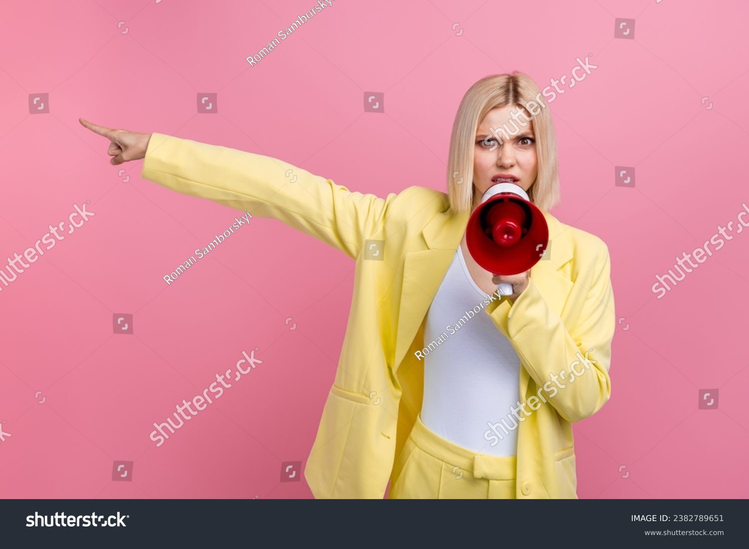 Portrait of negative outraged lady communicate scream loudspeaker point finger empty space isolated on pink color background #2382789651