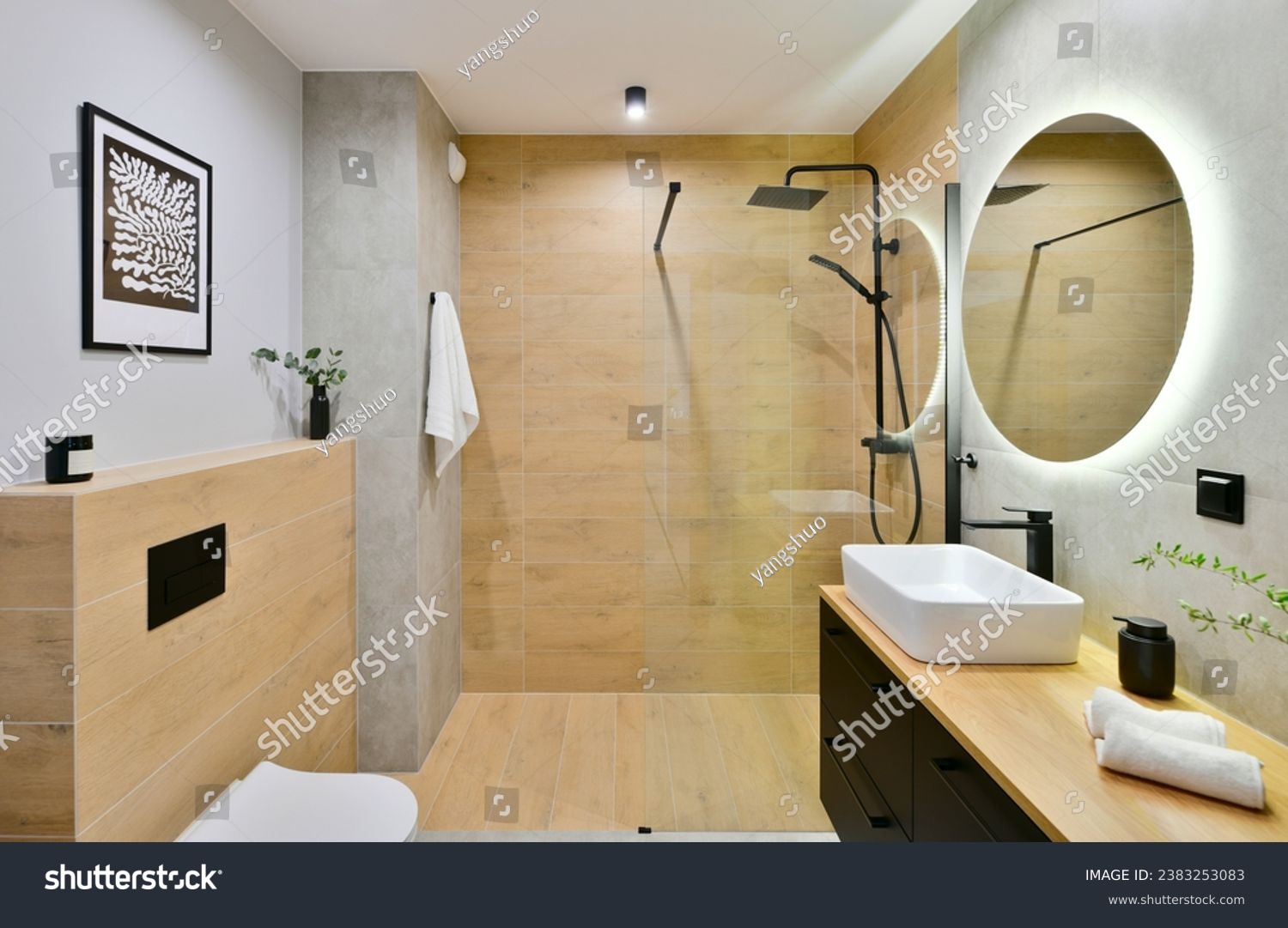 Decorated modern bathroom in boho style with a walk-in cabin, rain shower column and black built-in cabinets, with honey-colored wood-imitating tiles and round led light mirror #2383253083