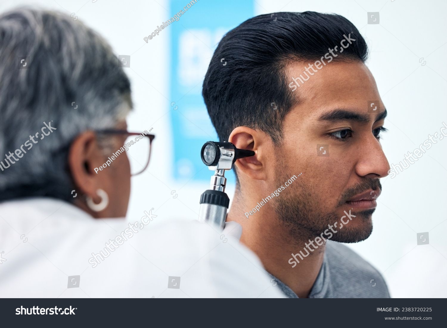Ear check, man and ENT doctor with patient consultation for hearing and wellness at hospital. Senior, employee and otoscope test of physician with healthcare work and consulting exam with expert #2383720225