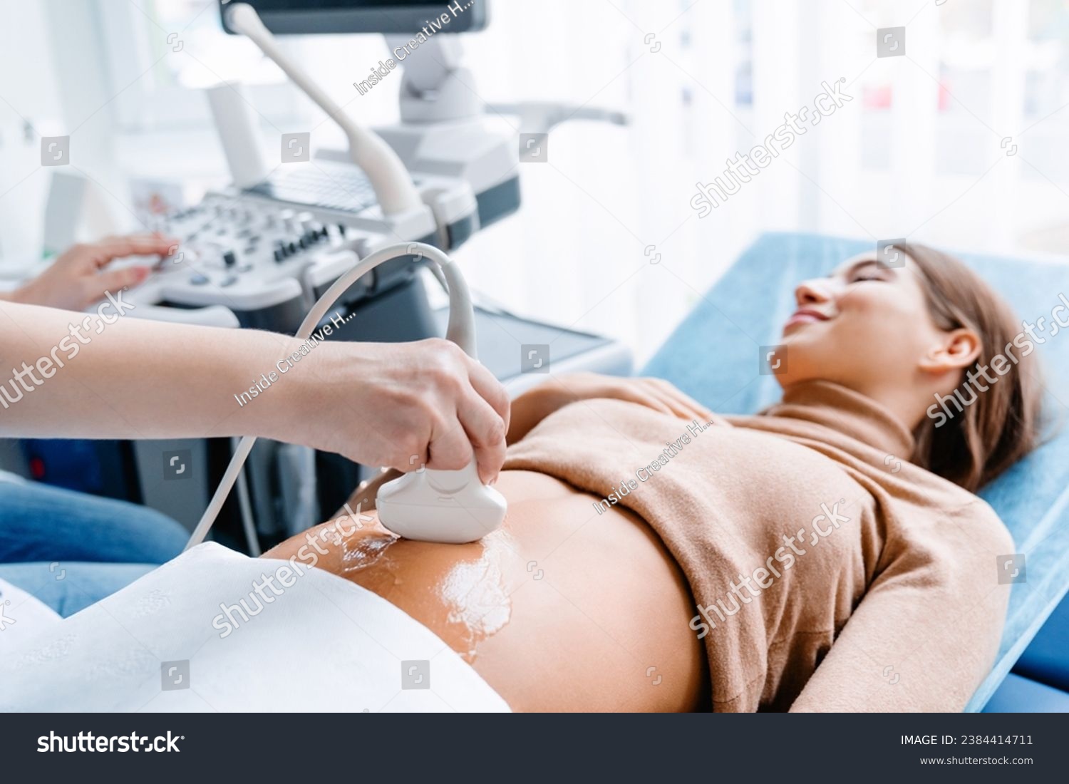 Doctor hand with ultrasonic during ultrasound medicine examination of pregnant patient. Maternity, pregnancy, fertility concept. Future mom checking on the embryo #2384414711