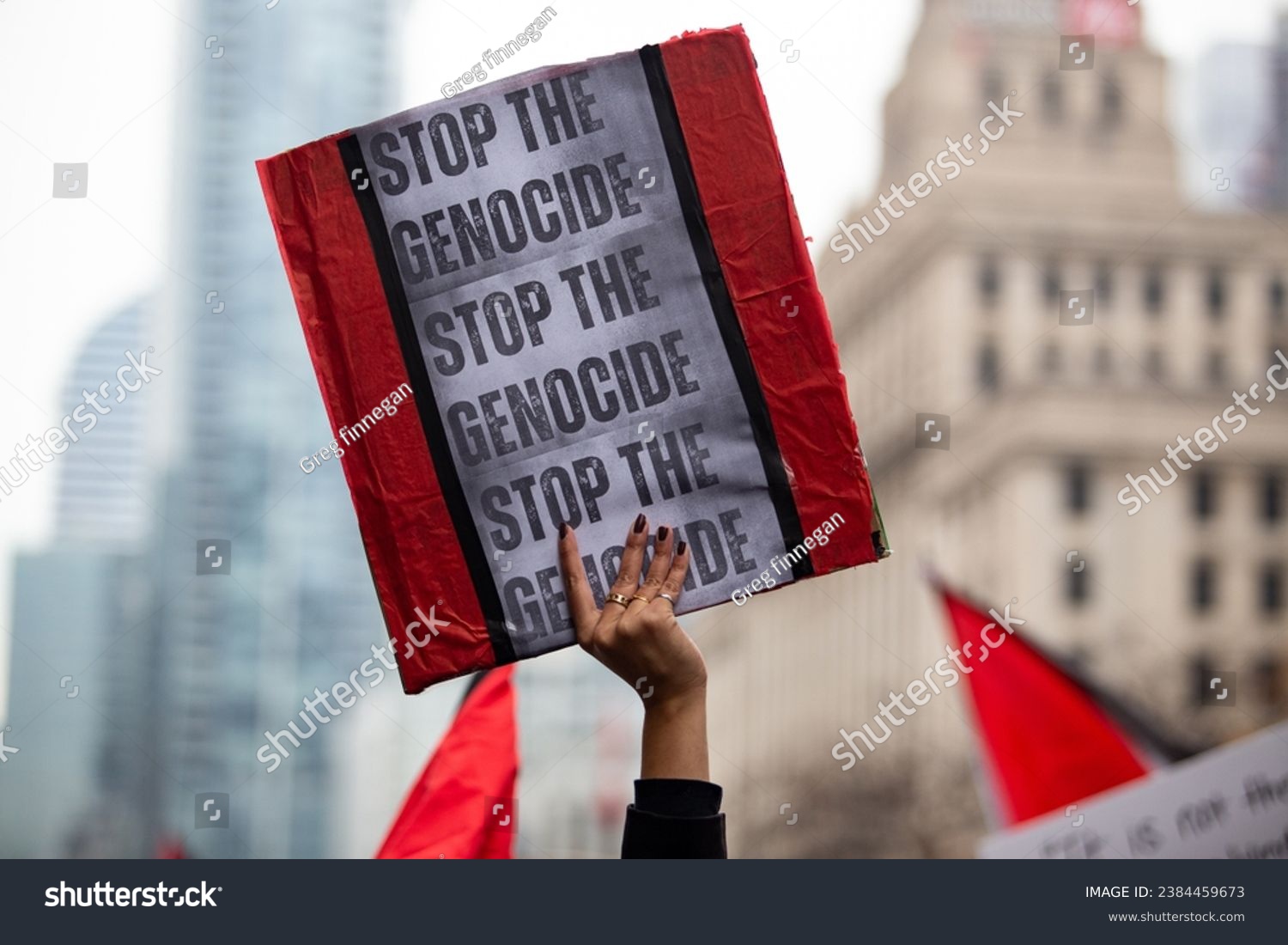 Person  holds up a sign saying Stop the Genocide  at a Palestinian demonstration Toronto Canada against the war in Gaza #2384459673