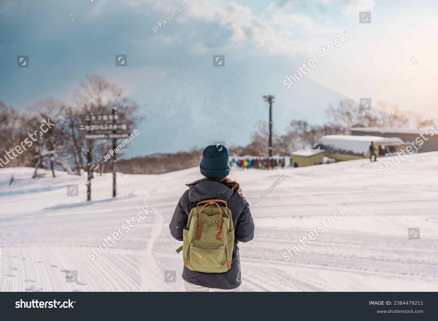 Woman tourist Visiting in Niseko, Traveler in Sweater sightseeing Yotei Mountain with Snow in winter season. landmark and popular for attractions in Hokkaido, Japan. Travel and Vacation concept #2384479211