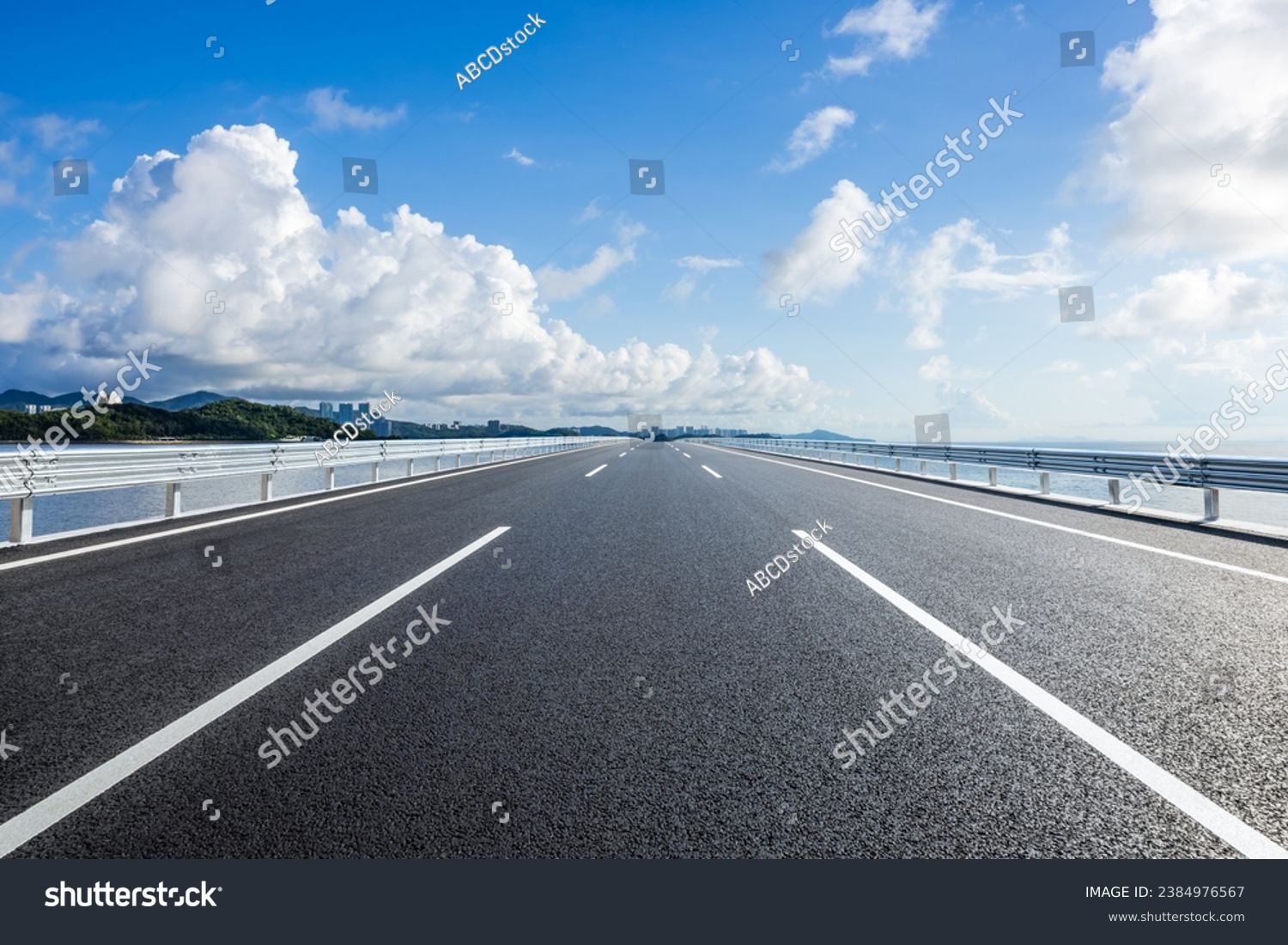 Straight asphalt highway and skyline under blue sky #2384976567