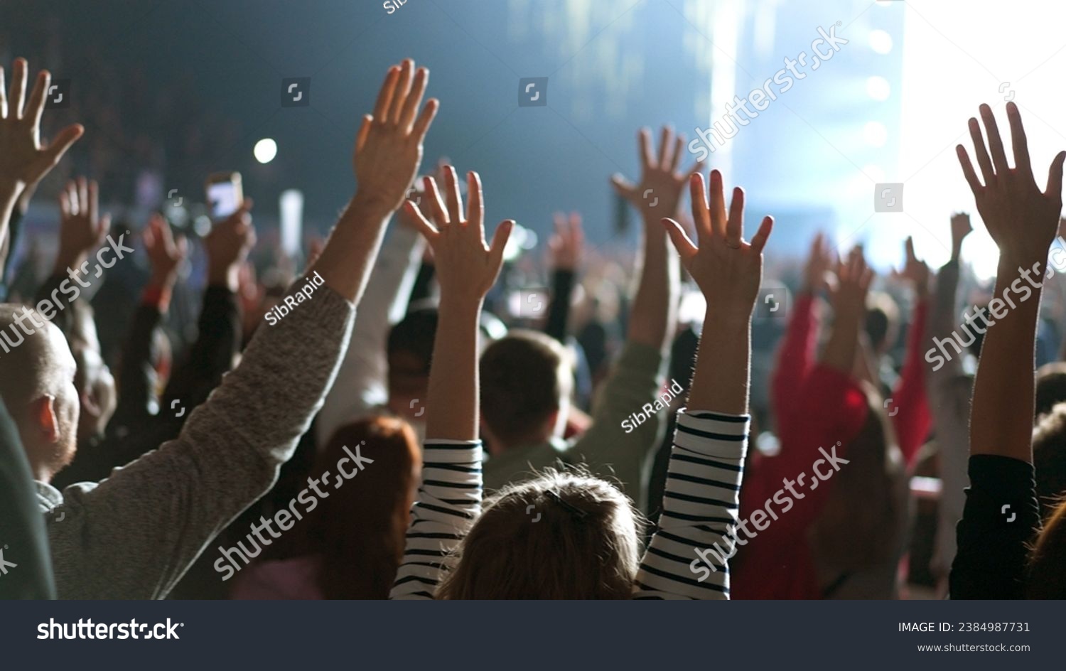 Many joy people raise hands up into sky. Fun live music concert. Sectarians crowd pray god. Lot sect fans follow faith. Holy worship concept. Epic rite open air. Big group lift arms. Huge ritual cults #2384987731