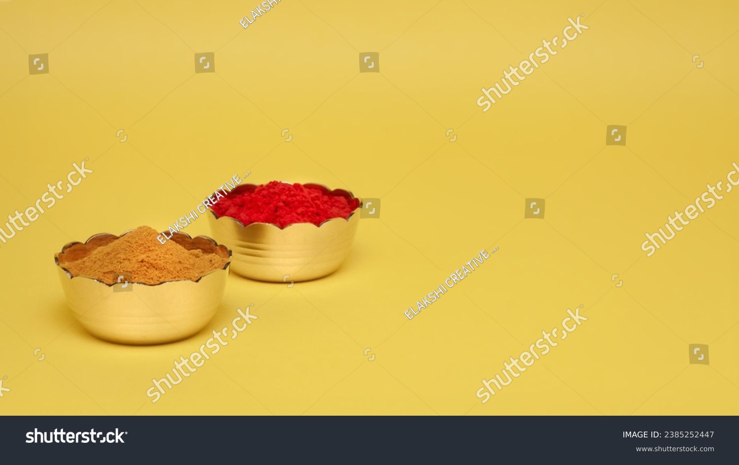 Hindu pooja objects, Auspicious red-colored Sindoor (vermilion) or kumkum, and Haldi in small brass bowls placed over a yellow background.  #2385252447