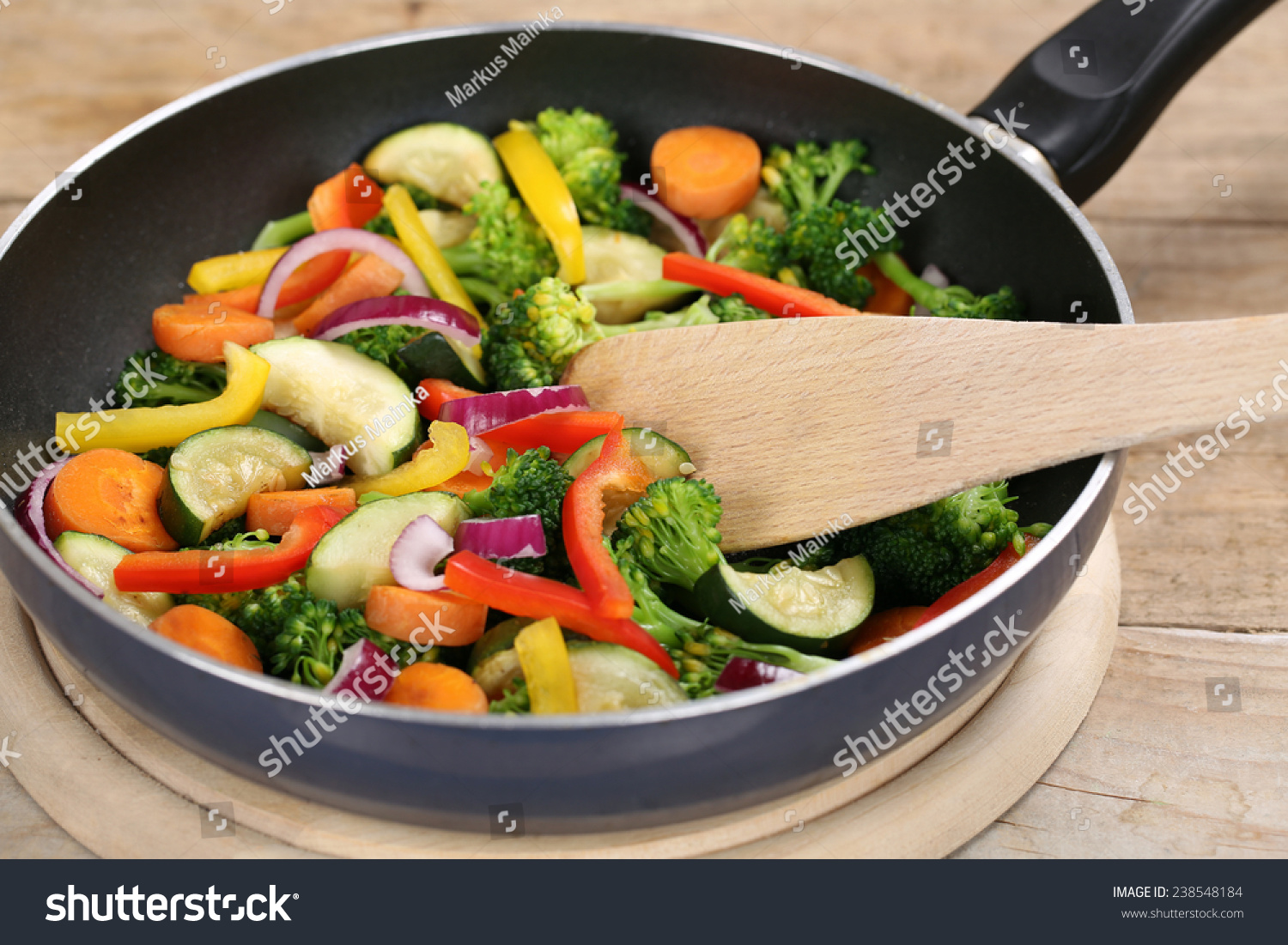 Healthy eating frying food with spatula vegetables in cooking pan #238548184