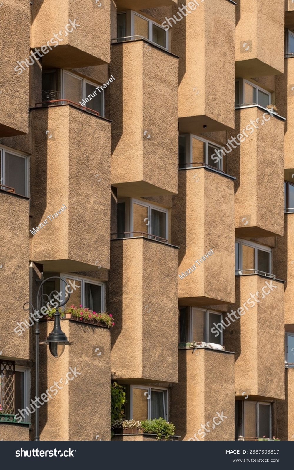 Modern architecture in the style of brutalism. Fragment of a concrete building with windows and balconies in Warsaw, Poland. New Brutalism is a branch of postwar architectural modernism.  #2387303817