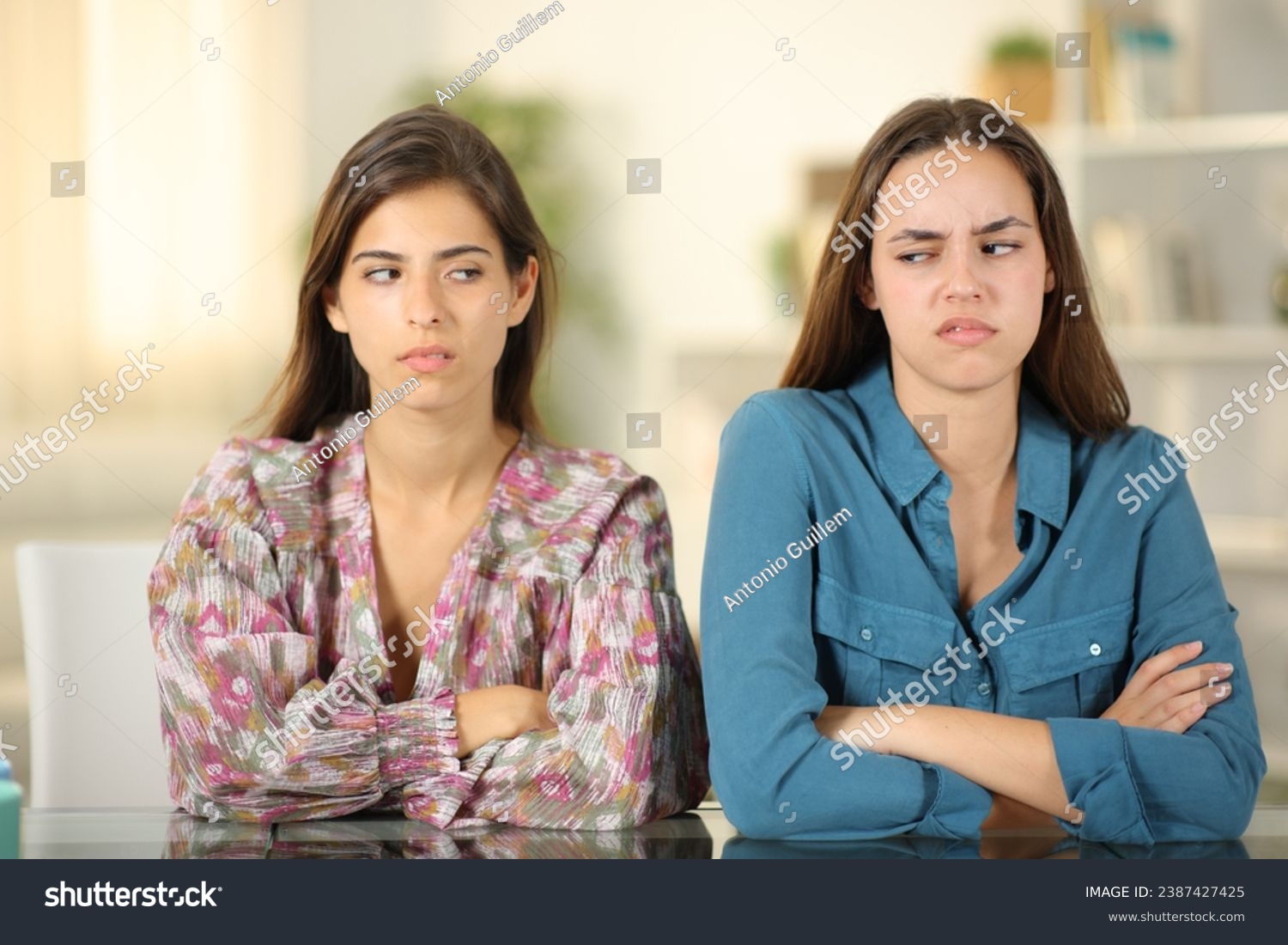 Front view portrait of two angry friends ignoring each other at home #2387427425