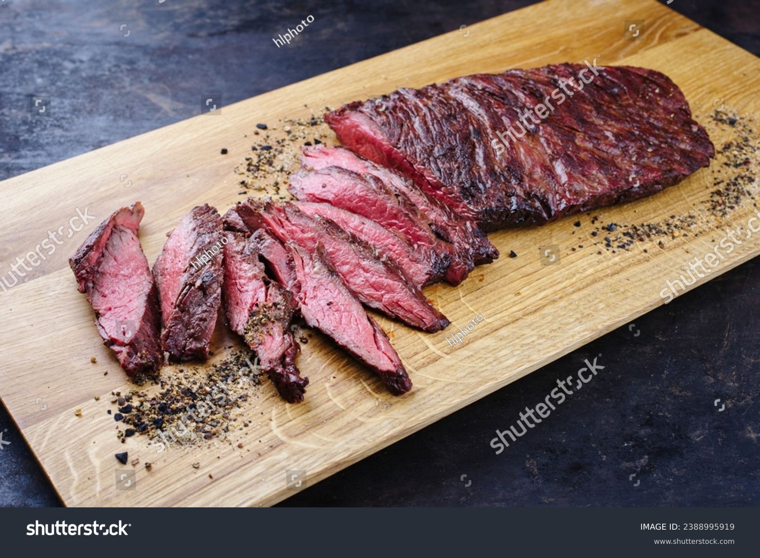Traditional American barbecue bavette steak with salt and pepper served as close-up on a modern design wooden board  #2388995919