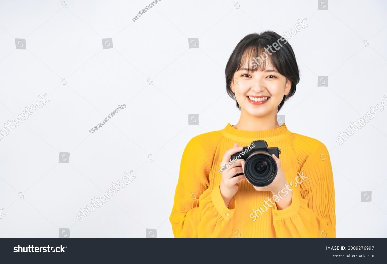 Asian woman wearing casual wear holding digital camera. Girl photographer. #2389276997