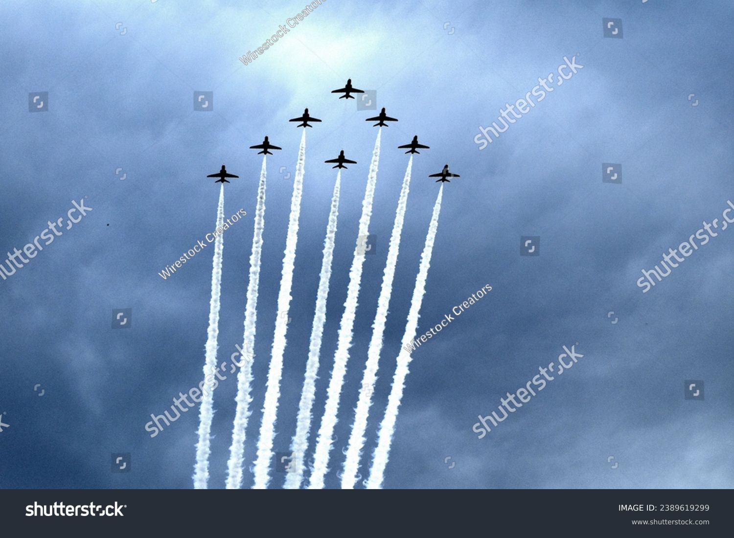 A picture of several airplanes in formation soaring through the sky, with white, billowing smoke trails trailing behind each one #2389619299