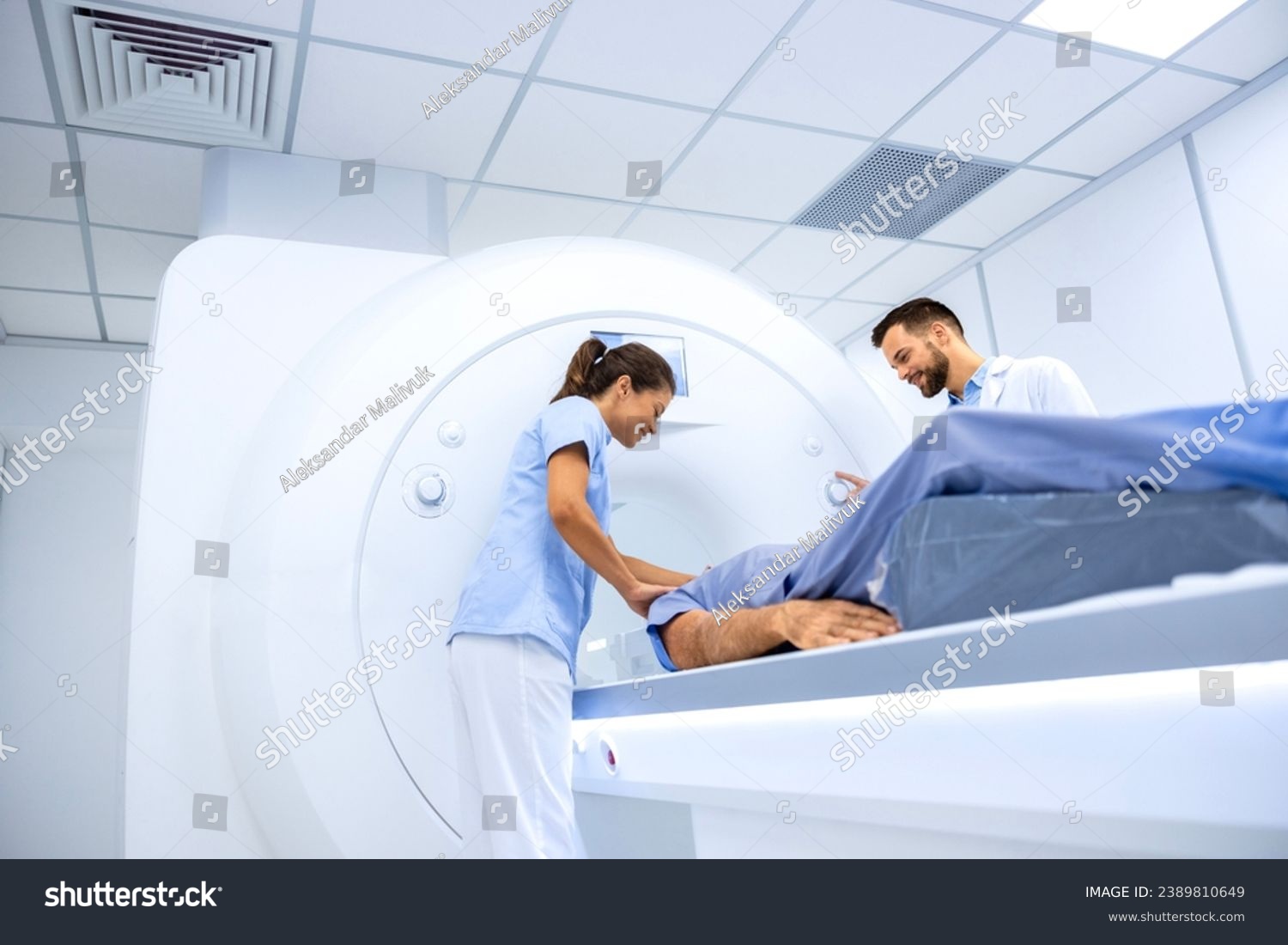 Doctors preparing patient for full body scanning procedure inside MRI diagnostic center. #2389810649