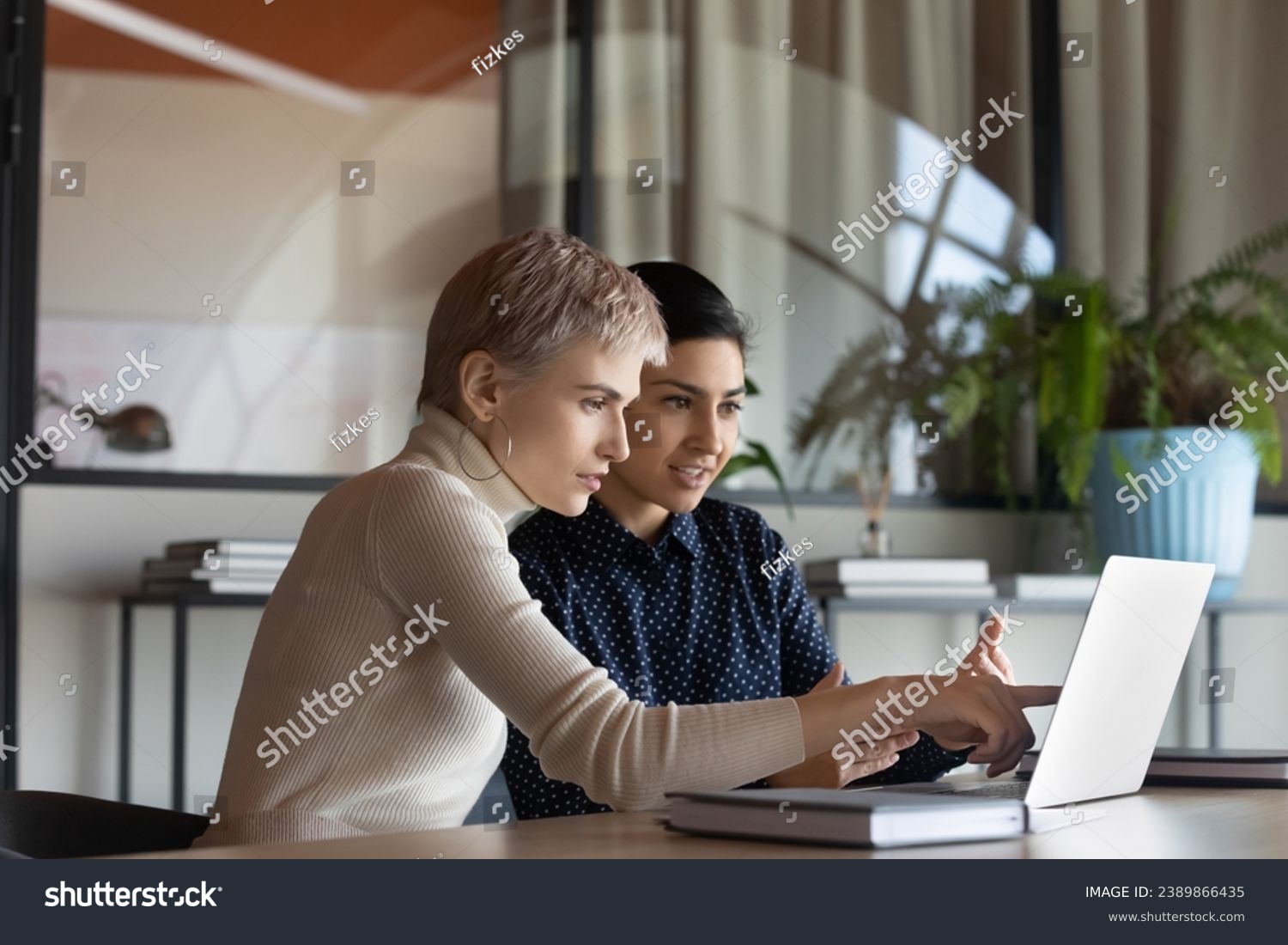 Corporate teacher showing new employee learning video at laptop, company mentor training intern. Diverse coworkers watching presentation, reading message, working together at computer #2389866435