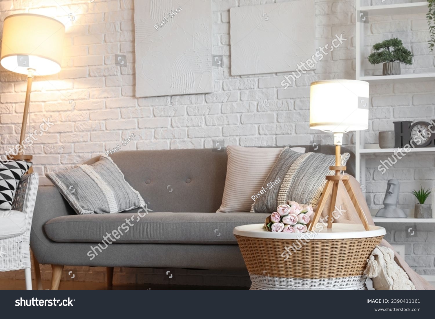 Interior of living room with cozy grey sofa and glowing lamps #2390411161