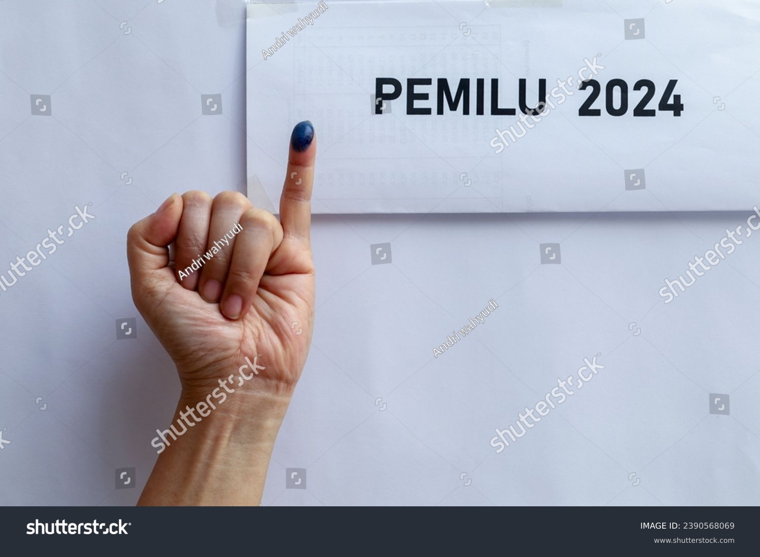 Indonesian election 2024. little finger with ink as a sign of voting rights, presidential election on the Indonesian election box. #2390568069