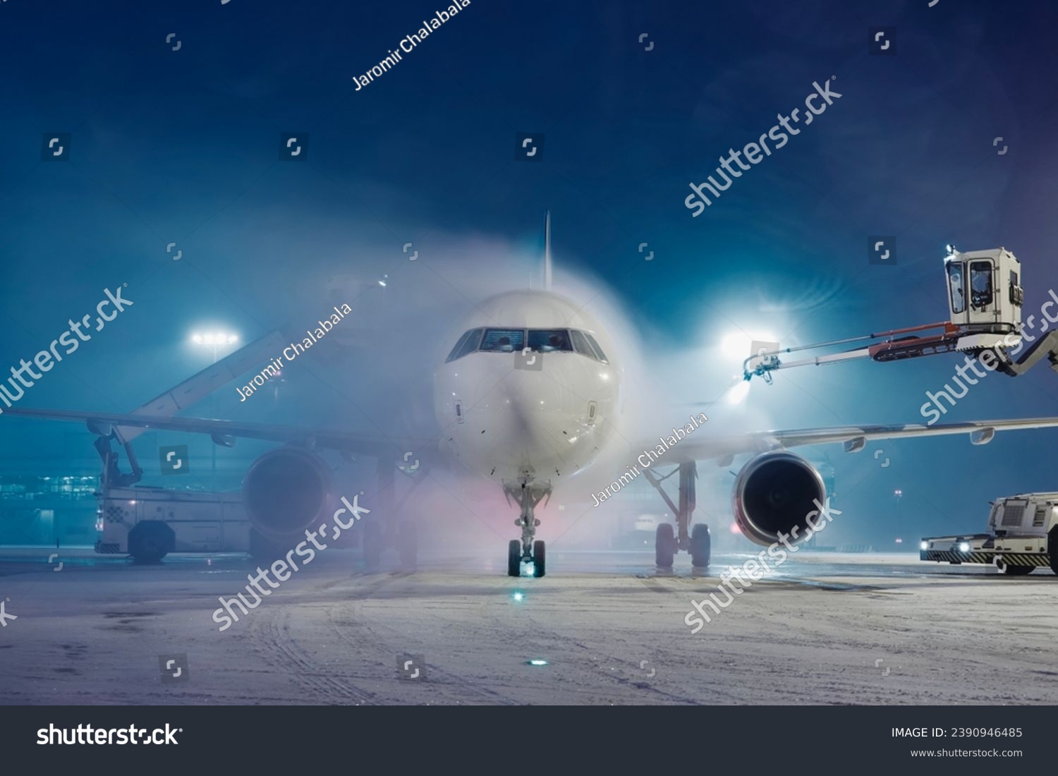 Deicing of airplane before flight. Winter frosty night and ground service at airport during snowfall.
 #2390946485