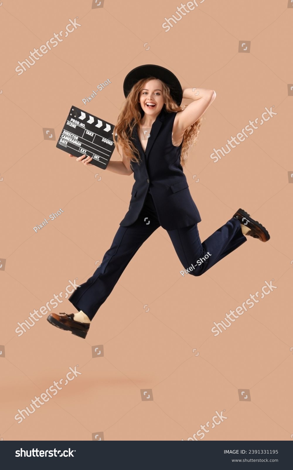 Beautiful actress with movie clapper jumping on beige background #2391331195