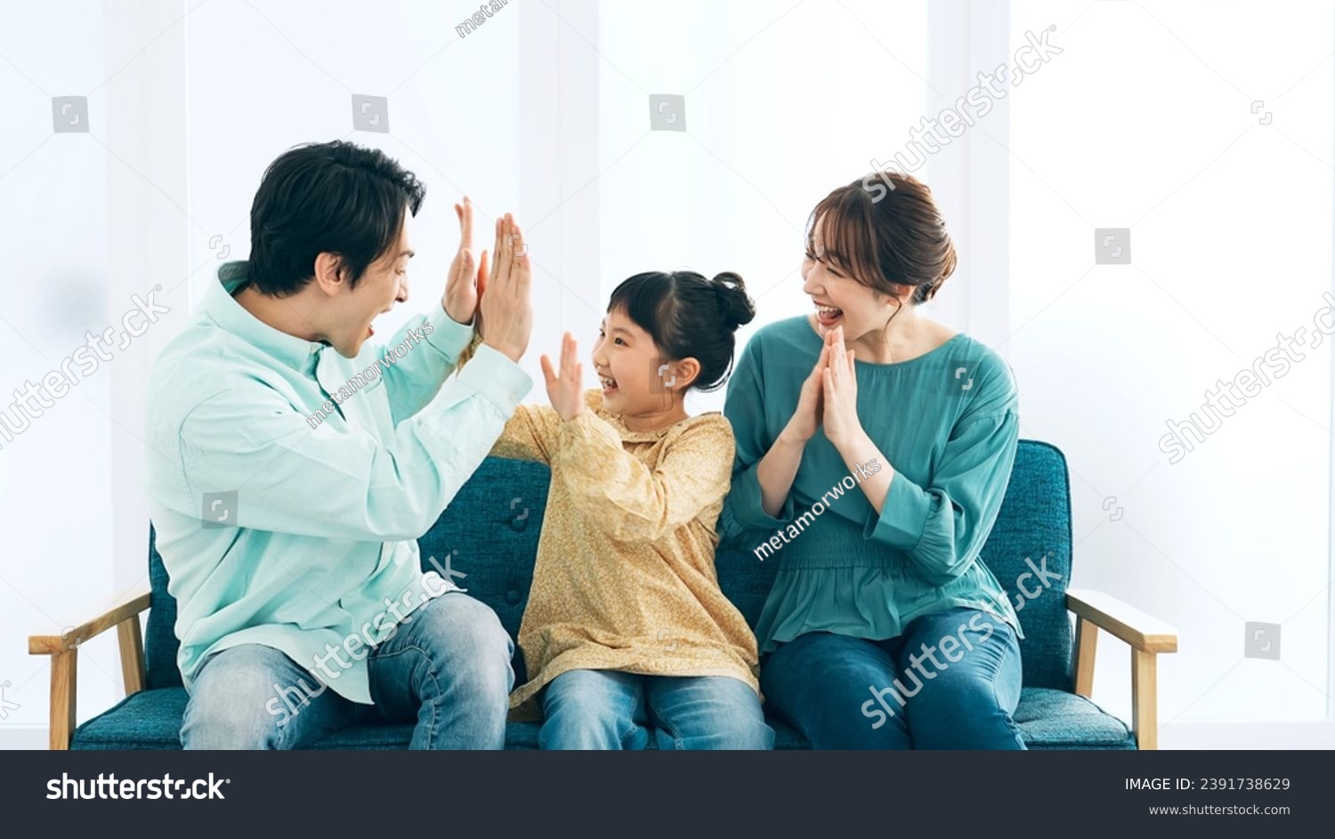 Asian family getting excited watching TV. Watching sports. #2391738629