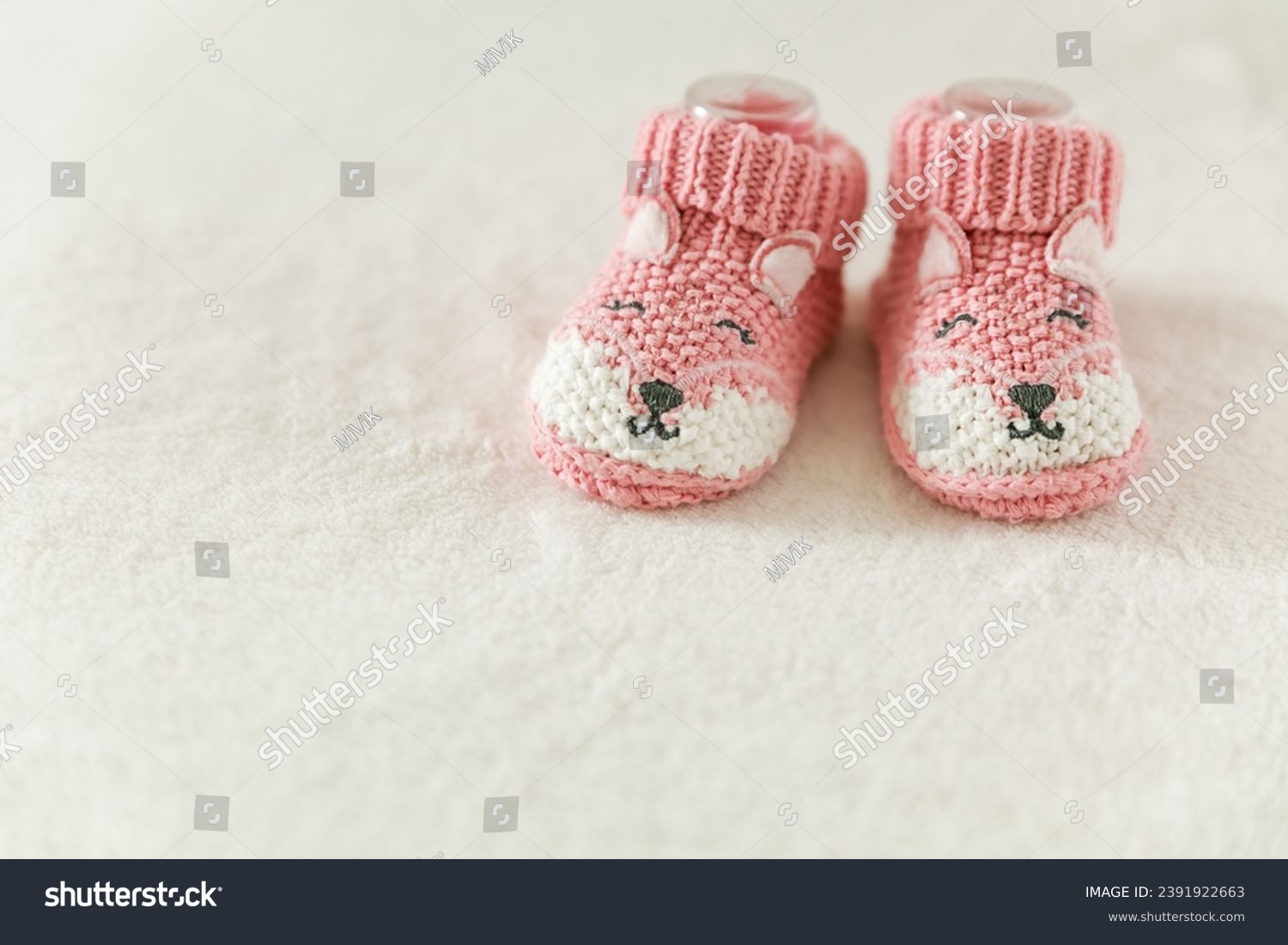 Pink knitted baby socks, booties on a white background with copy space. Pregnancy and motherhood concept, first birthday banner, handmade socks, baby warm clothes, handmade knitted socks, hobby #2391922663