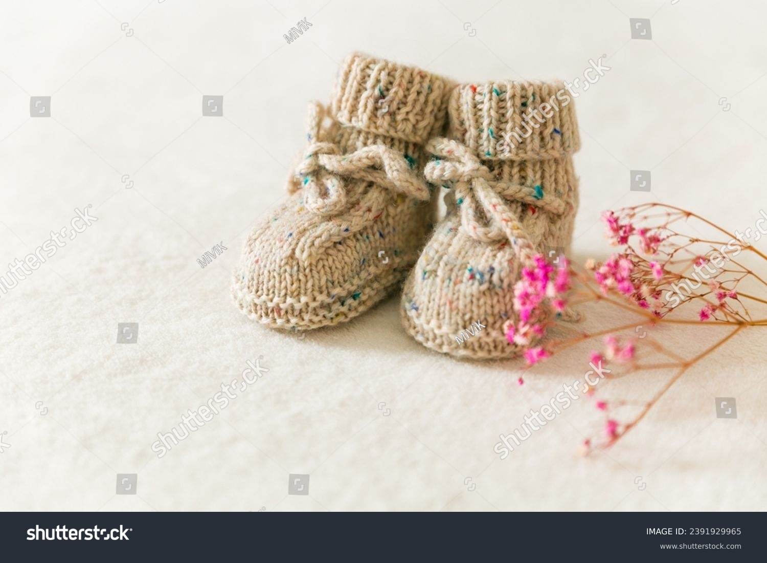 Knitted baby socks, booties on a white background with copy space. Pregnancy and motherhood concept, first birthday banner, handmade socks, baby warm clothes, handmade knitted socks, hobby. #2391929965