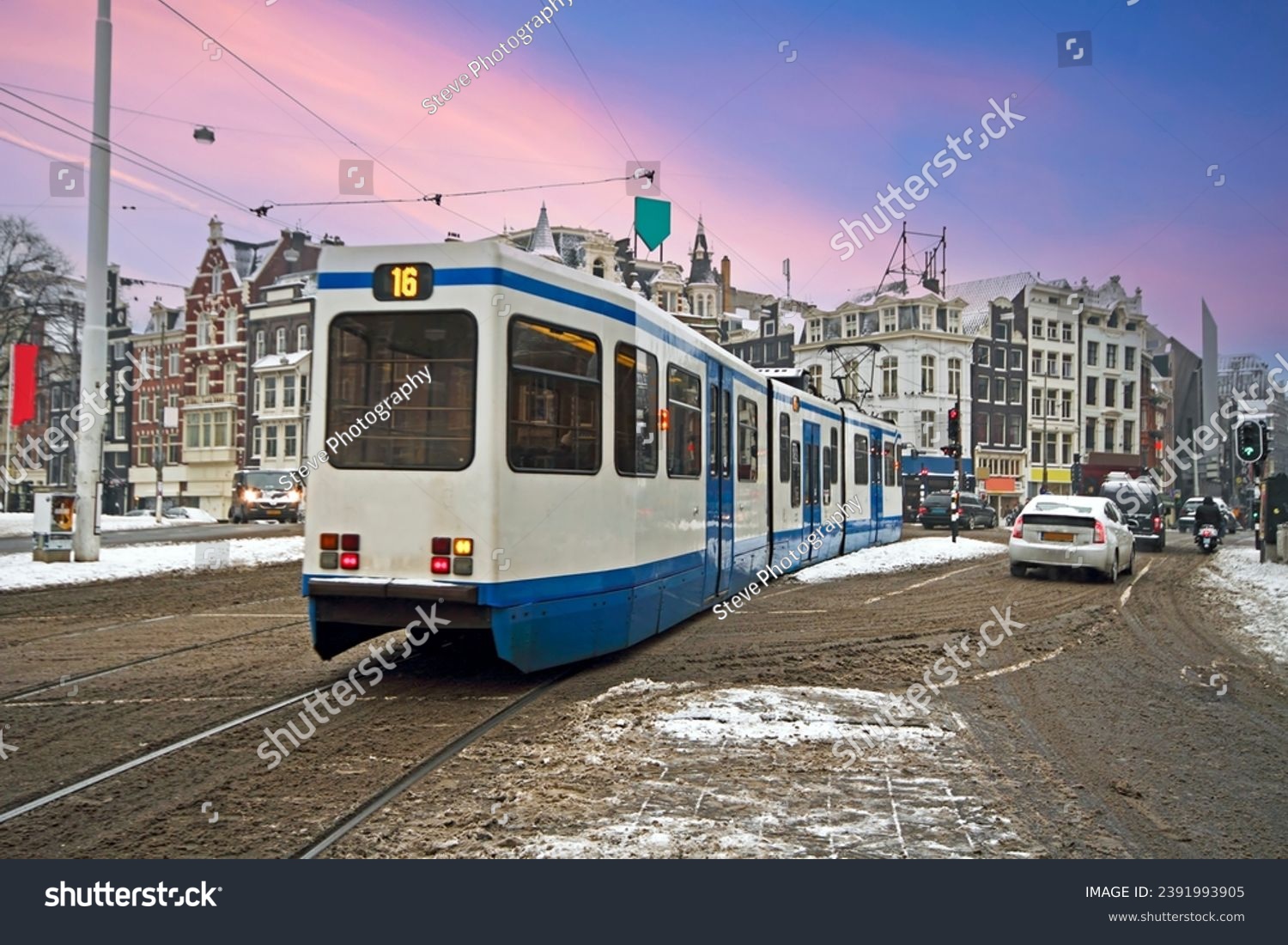 Tram driving in snowy Amsterdam in the Netherlands at sunset #2391993905