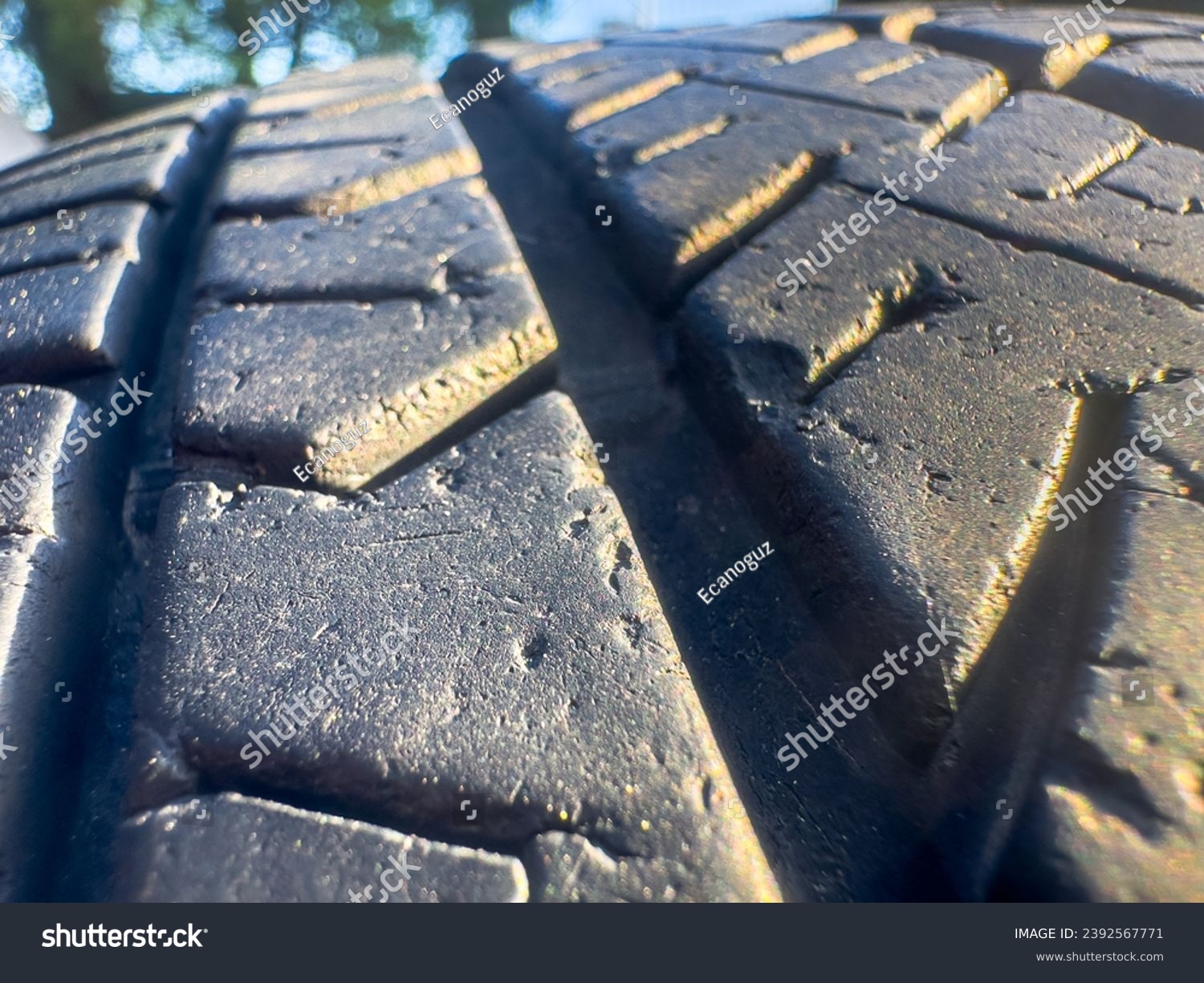 In this detailed close-up photograph, the intricate textures and patterns of a tire's rubber surface come into focus. #2392567771