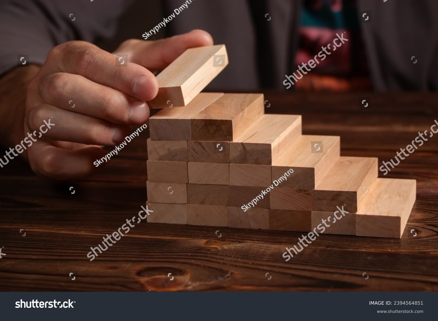 a business man build a blocks wood game. #2394564851