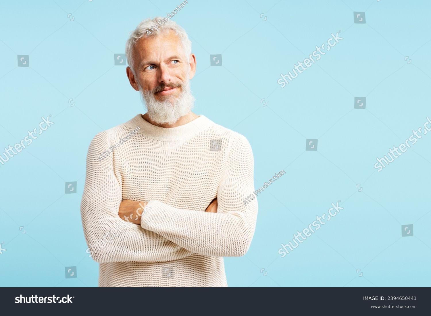 Portrait of handsome mature Scandinavian man wearing stylish sweater looking away, choosing something isolated on blue background, copy space. Shopping, store concept  #2394650441