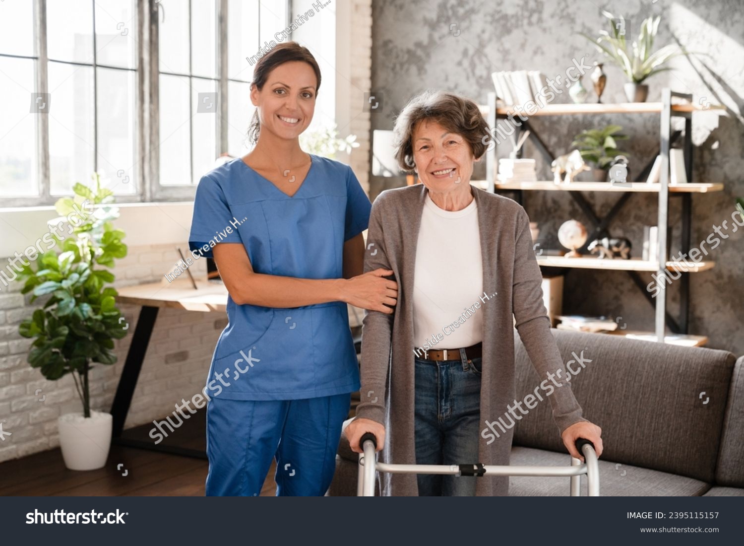 Portrait pf happy smiling caretaker medicine worker nurse helping elderly senior old patient with walking frame. Rehabilitation after trauma injury #2395115157