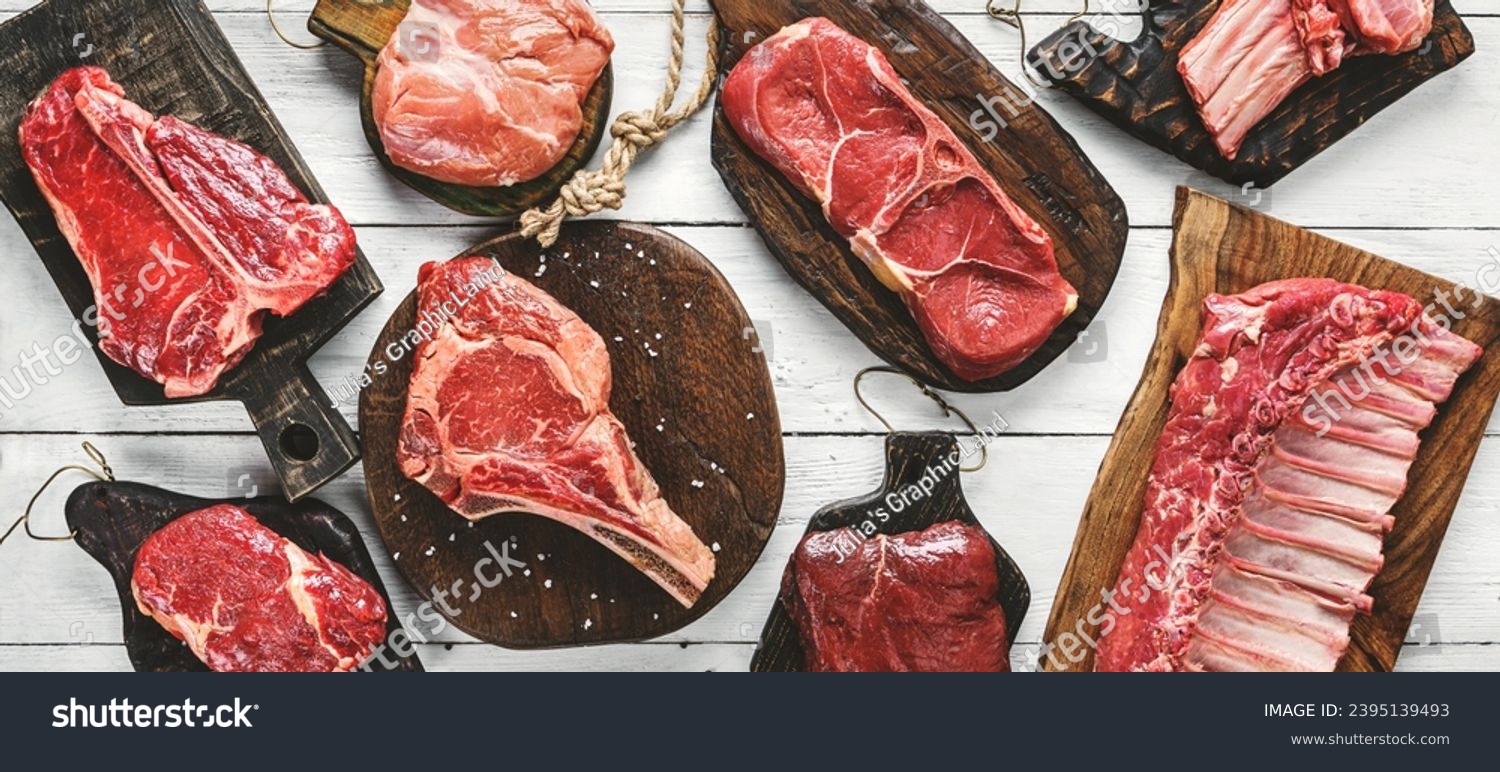 Set of various raw meat steaks. Fresh meat of beef, pork, veal, chicken, steak t-bone, rib eye, tomahawk, ribs, tenderloin on cutting board over white background. Meat food, butcher shop, top view #2395139493