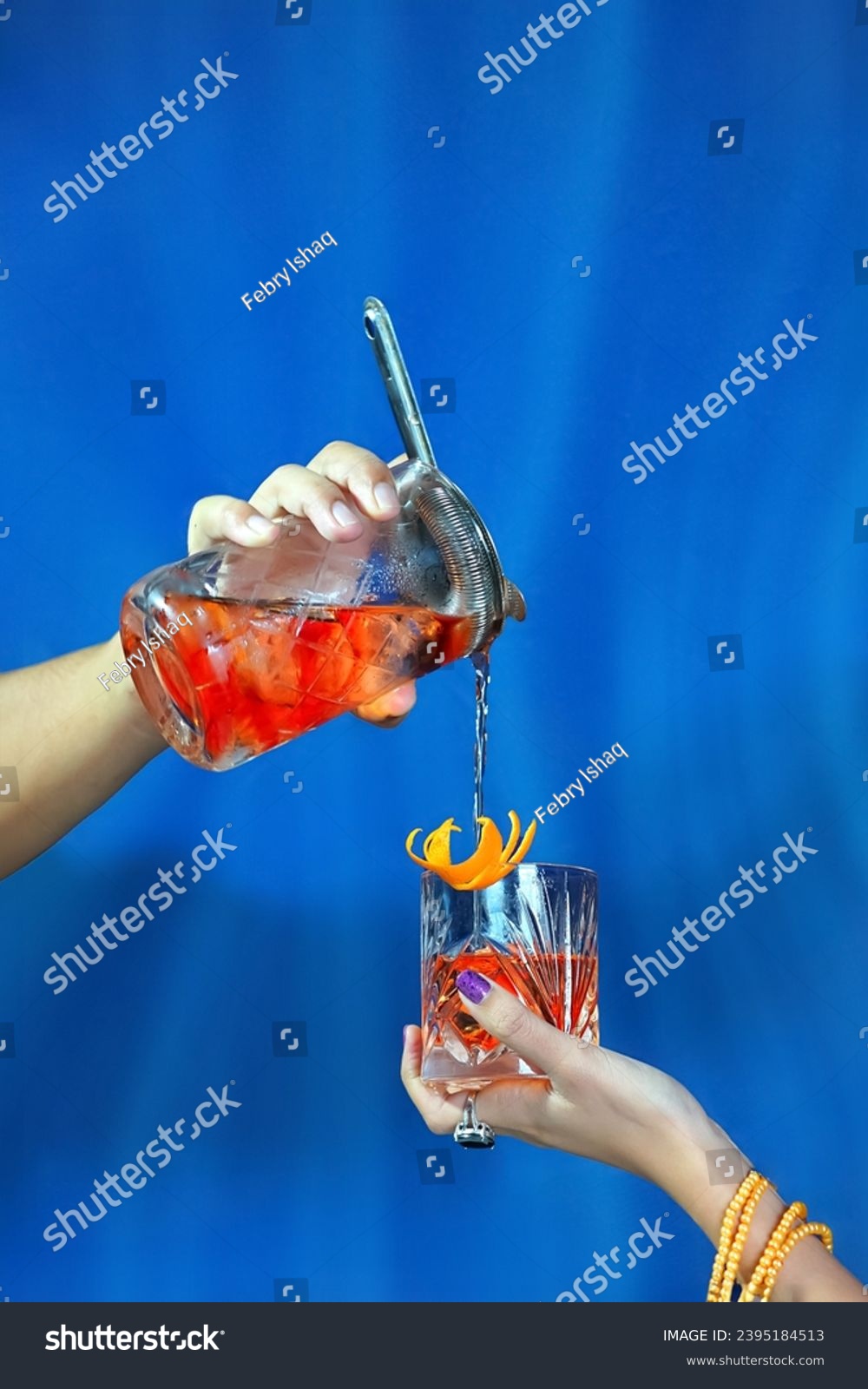 Pouring The Classic Negroni Cocktail into Glass #2395184513