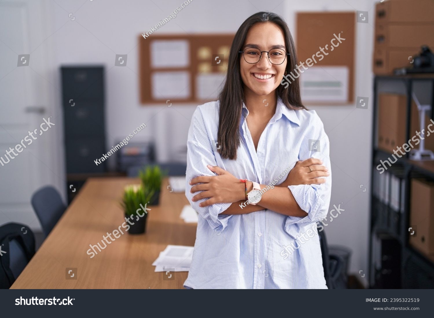 Young hispanic woman at the office happy face smiling with crossed arms looking at the camera. positive person.  #2395322519