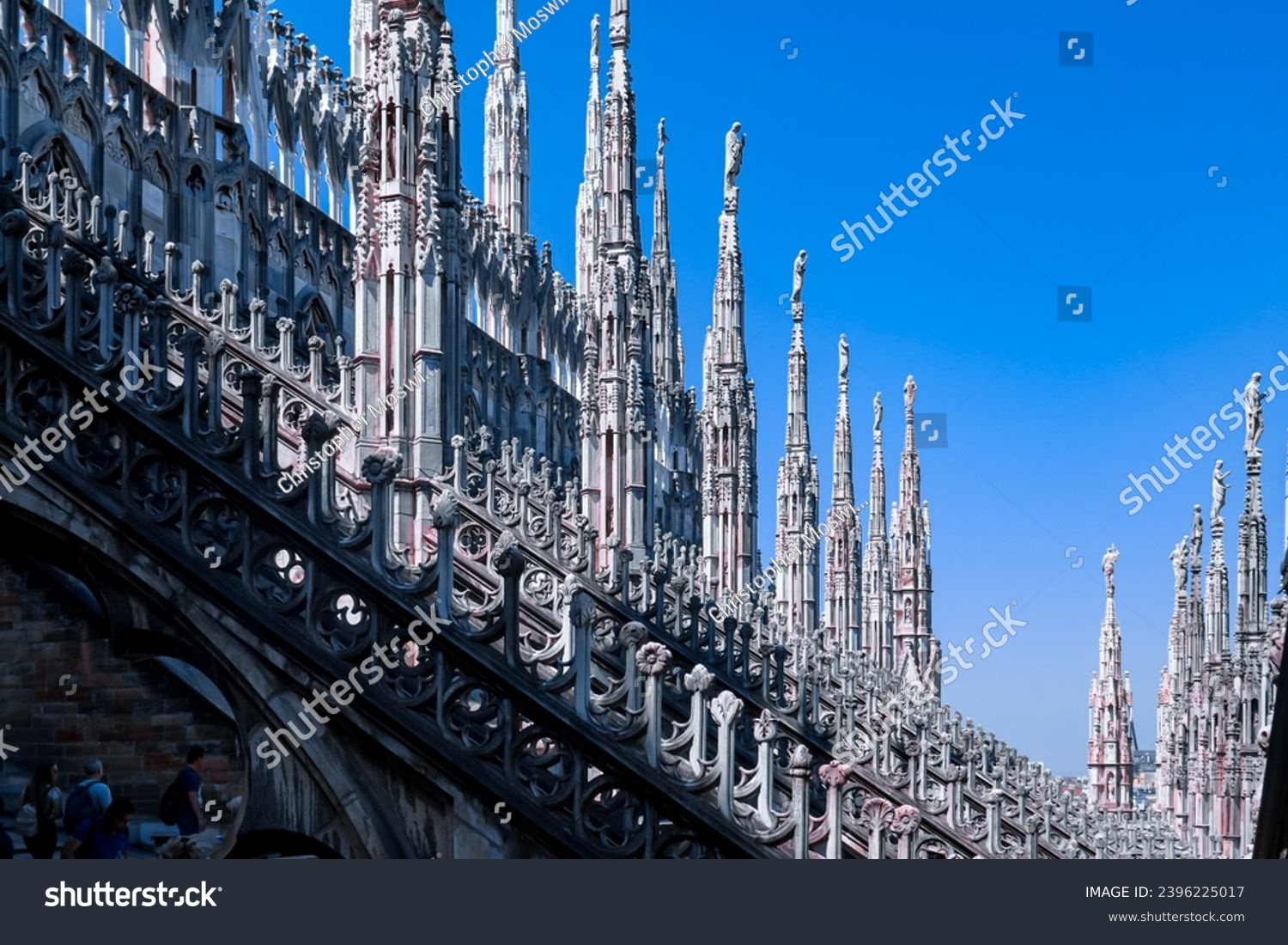 External view of Milan Cathedral (Duomo di Milano) from the rooftop, Milan, Lombardy, Italy, Europe. Historical marble facade with spires. Gothic architecture features. City travel tourism #2396225017