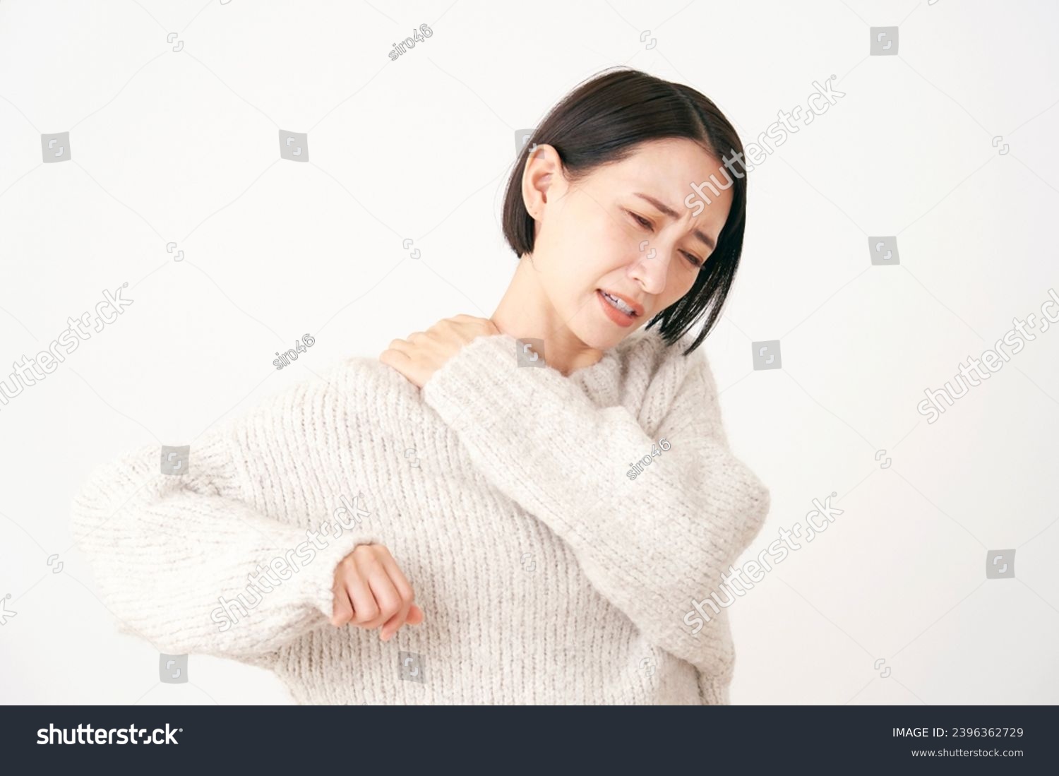 Asian middle aged woman having stiff shoulders in white background #2396362729