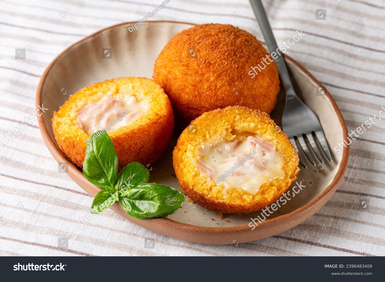 Arancini are Italian rice balls that are stuffed, filled with ham prosciutto and mozzarella, coated with breadcrumbs and deep fried.  Sicilian snack, street food.  #2396483409