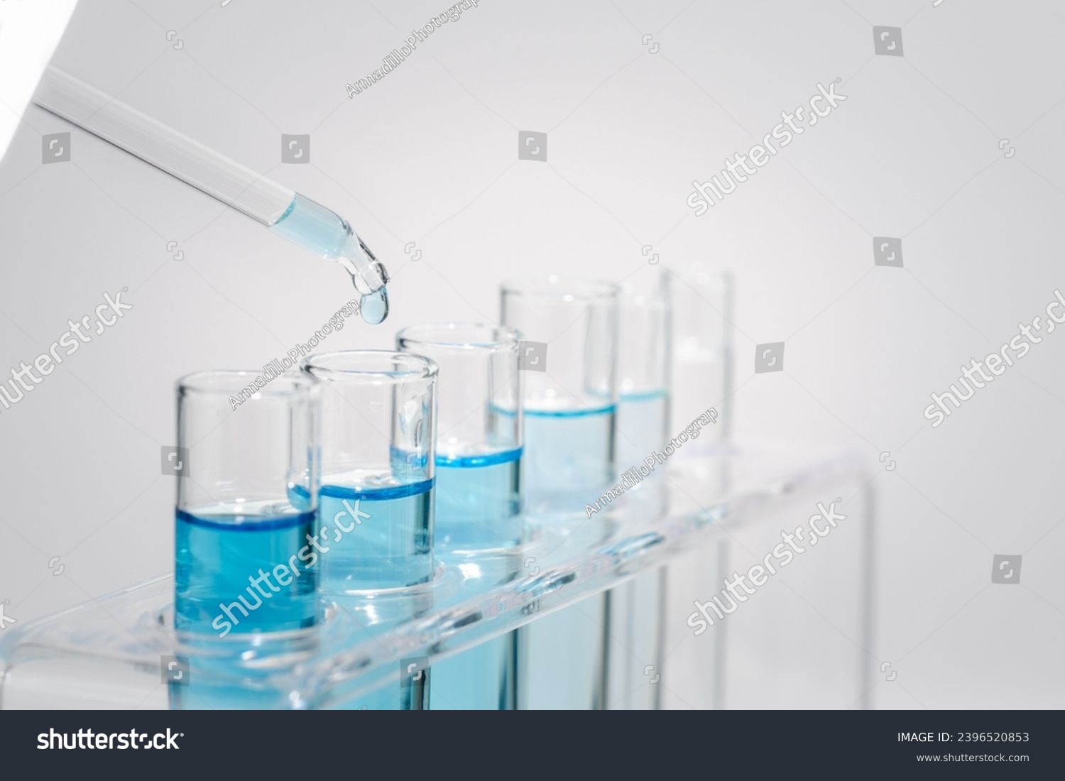 Chemistry laboratory tube glass, science laboratory research and development concept, flask, beaker, and test tubes with dropping blue liquid water sample test, scientific test tubes equipment. #2396520853