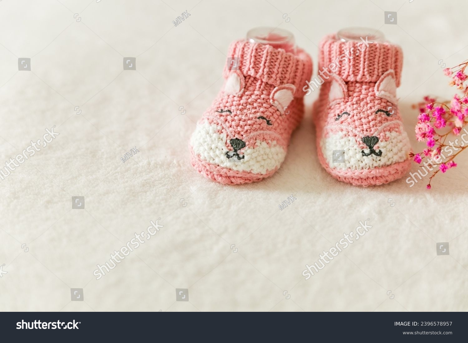 Pink knitted baby socks, booties on a white background with copy space. Pregnancy and motherhood concept, first birthday banner, handmade socks, baby warm clothes, handmade knitted socks, hobby. #2396578957