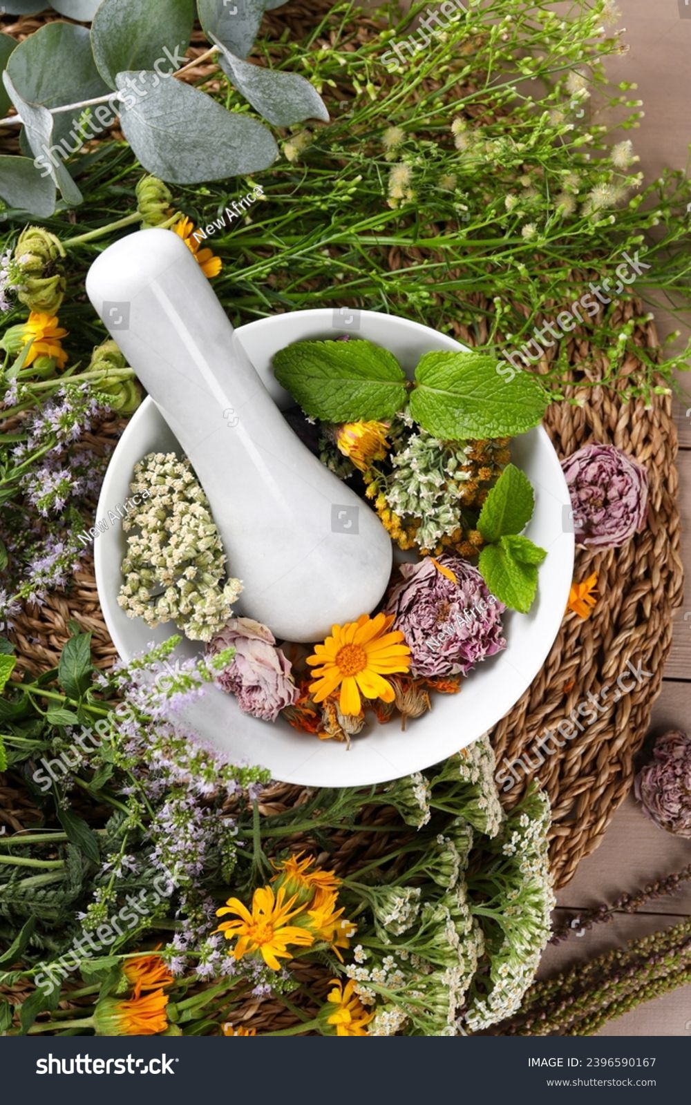 Mortar with pestle and many different herbs on table, flat lay #2396590167