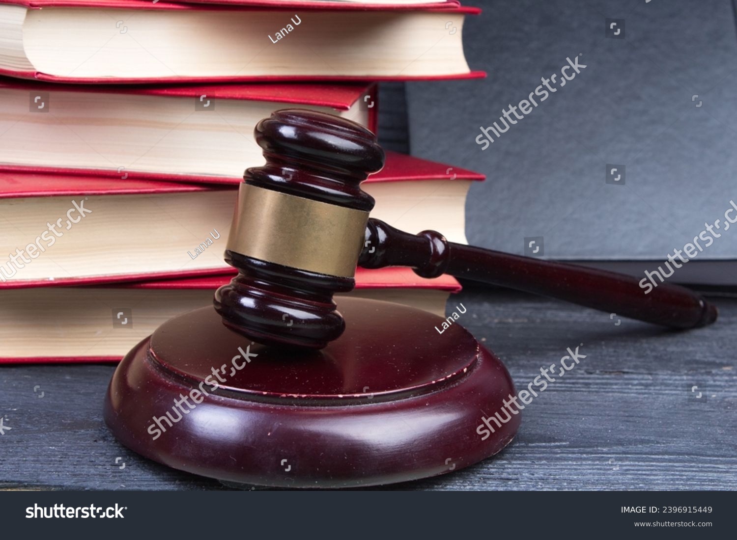 Law concept - Open law book with a wooden judges gavel on table in a courtroom or law enforcement office on blue background. Copy space for text #2396915449