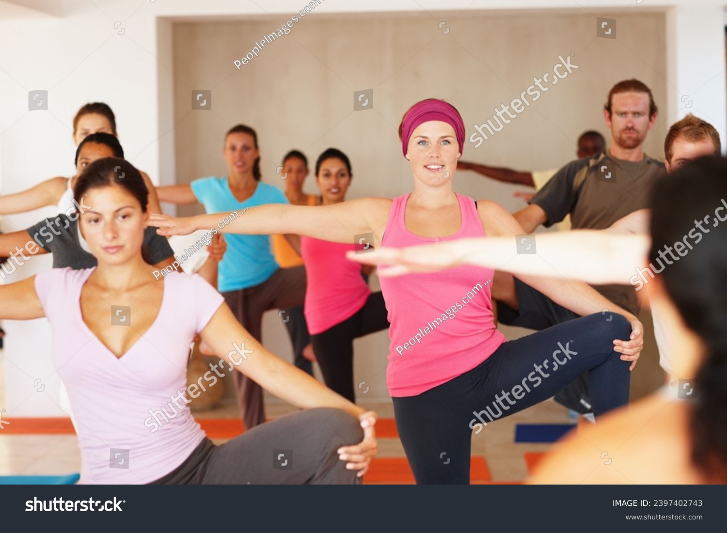 Yoga class, stretching knee and people with coach at gym, exercise and healthy body or wellness. Fitness, happy group and instructor practice flexibility, balance legs and pilates in club together #2397402743
