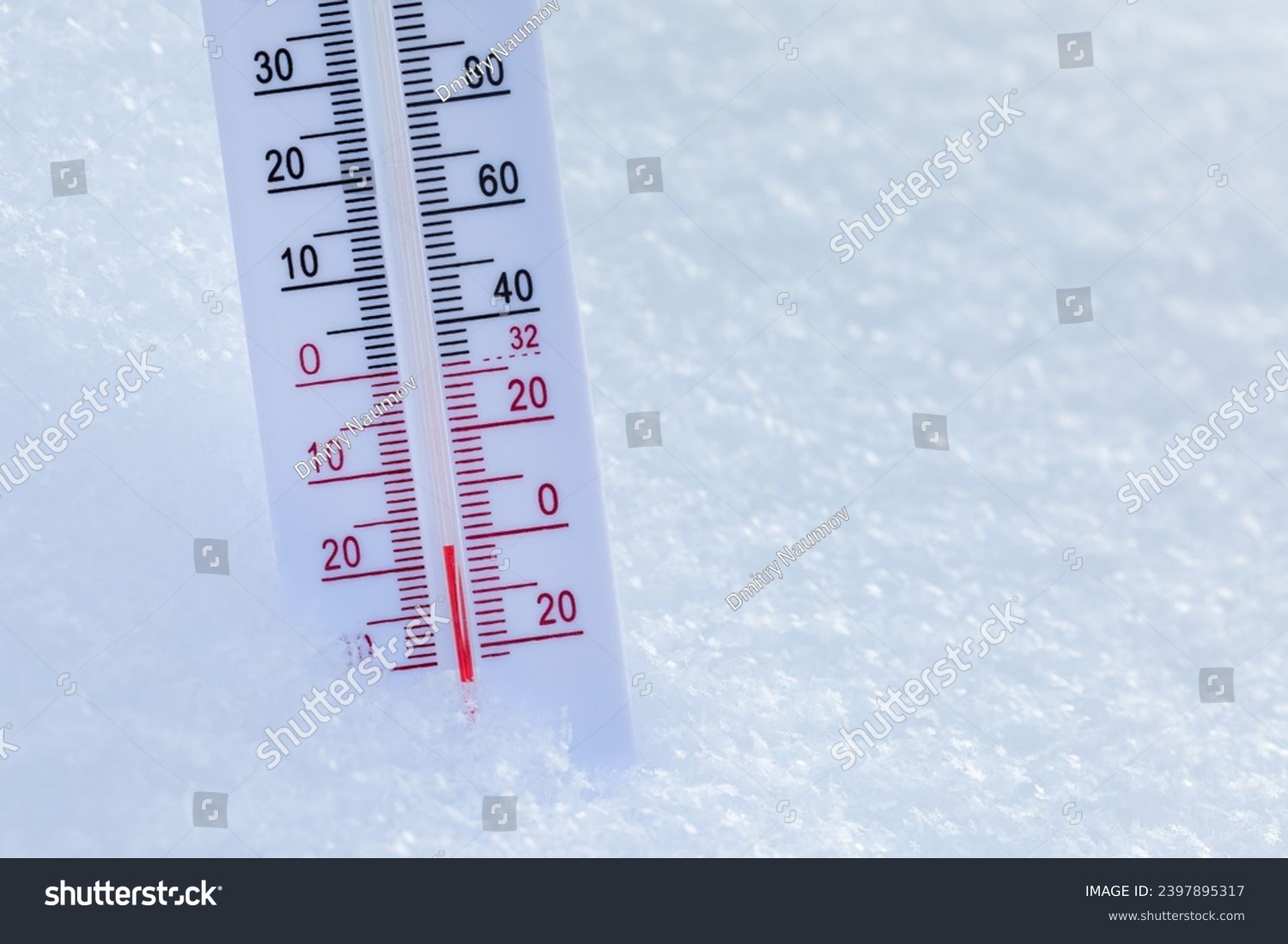 Thermometer with both Celsius and Fahrenheit scales placed in fresh snow indicating freezing cold winter temperature #2397895317